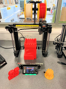 3D printer loaded with PLA, and some printed articles